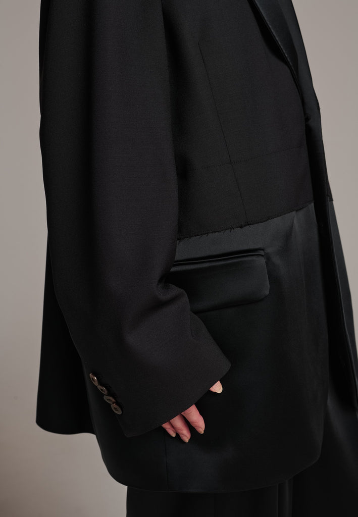 Creative Director Erik Frenken is a master of designing cool, oversized silhouettes, and this blazer is no exception. Precisely tailored with tuxedo-influenced satin lapels and needle point stitching. Full viscose satin lining, handy flap pockets. Horn square button fastenings. This piece will elevate every outfit to the next level, from jeans to dresses, and could easily become your everyday treasure.