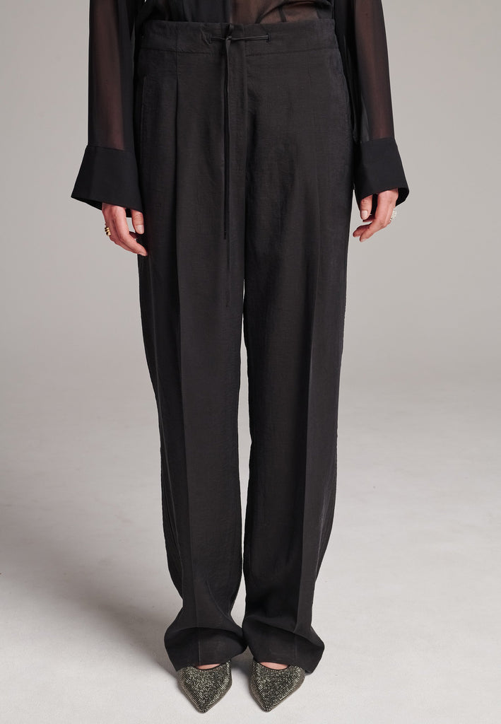 Easy-wear trousers featuring regular cut and drawstring fastening. Detailed with side slit and rear welt pockets. Cut from a light wrinkled viscose with washed look that emphasizes the relaxed attitude. As a nod to the tuxedo pants, it has a self-fabric side seam stripe.