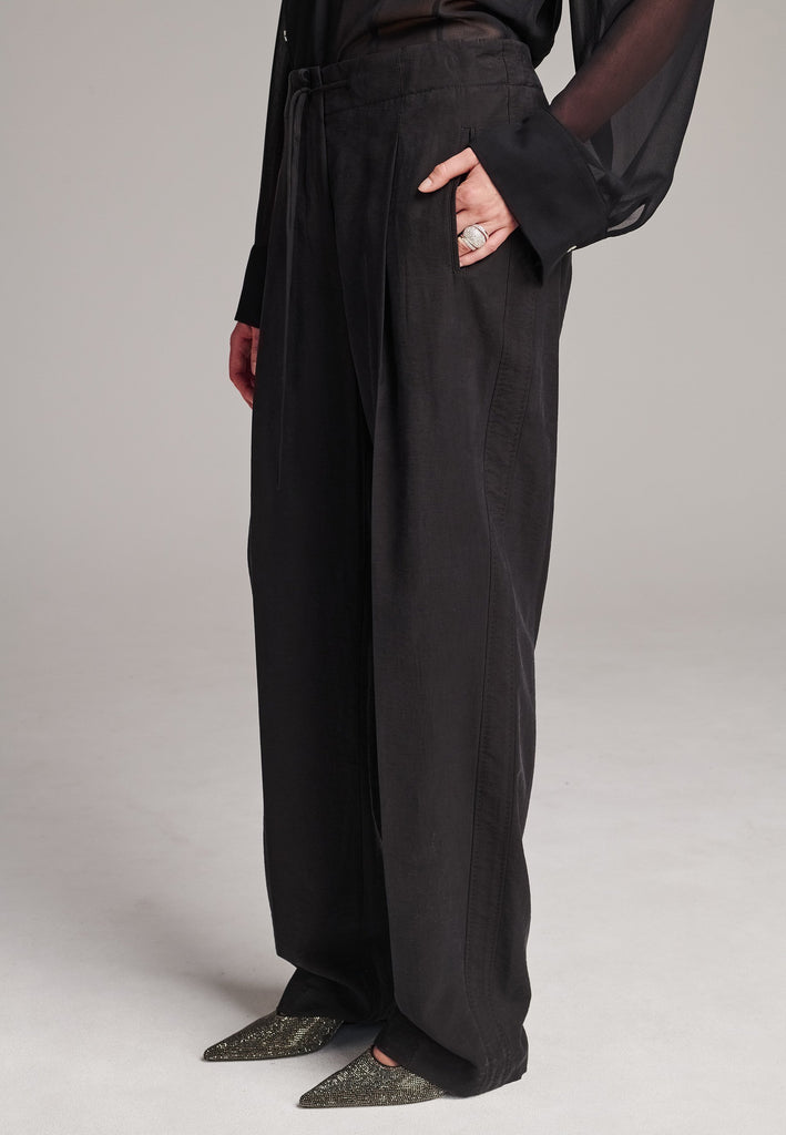 Easy-wear trousers featuring regular cut and drawstring fastening. Detailed with side slit and rear welt pockets. Cut from a light wrinkled viscose with washed look that emphasizes the relaxed attitude. As a nod to the tuxedo pants, it has a self-fabric side seam stripe.