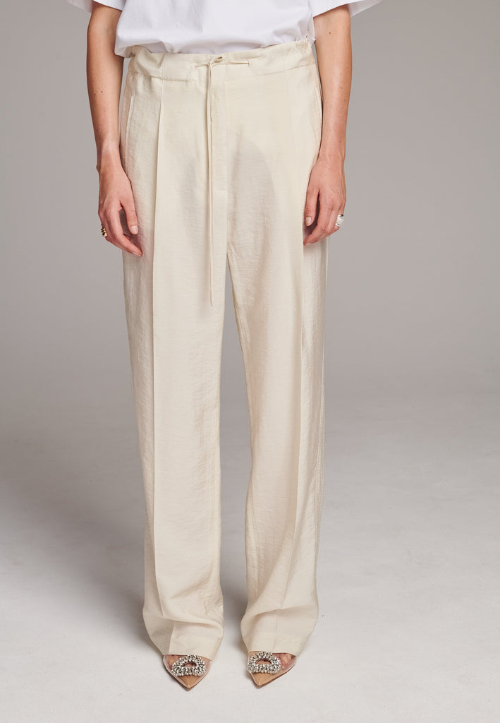 Easy-wear trousers featuring regular cut and drawstring fastening. Detailed with side slit and rear welt pockets. Cut from a light wrinkled viscose with washed look that emphasizes the relaxed attitude. As a nod to the tuxedo pants, it has a self-fabric side seam stripe.