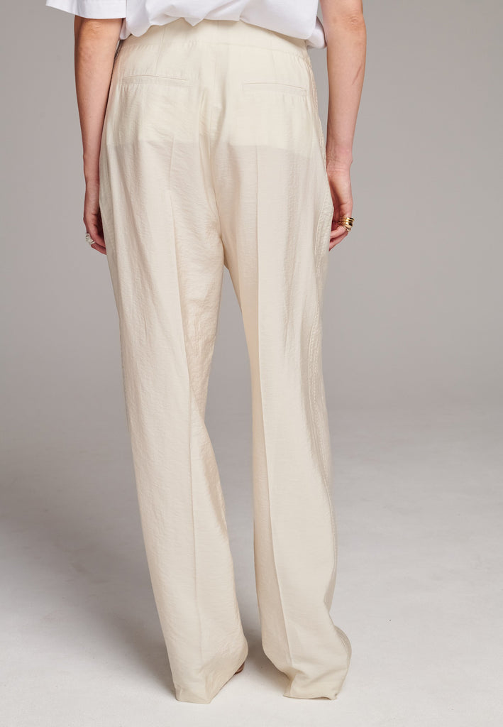 Easy-wear trousers featuring regular cut and drawstring fastening. Detailed with side slit and rear welt pockets. Cut from a light wrinkled viscose with washed look that emphasizes the relaxed attitude. As a nod to the tuxedo pants, it has a self-fabric side seam stripe.