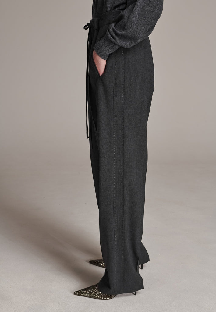 Refine your wardrobe with these straight-leg trousers, cut from a soft virgin wool. Featuring a sophisticated horn button and zip with a drawstring fastening at the waist. With a nod to the tuxedo pants, it has a fabric self-stripe with a needle point at the side seam. Complete with slanted pockets and welt back pockets, these trousers blend traditional elegance with modern functionality.