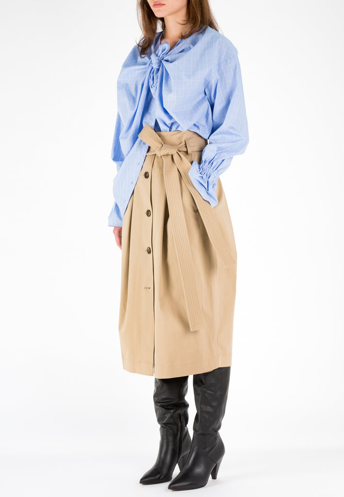 Camel skirt with belt. A sculptural midi skirt in heavy cotton. With two pleats at the front and at the back. A long double stitched belt. This classic camel is easy to combine. Model wears a size 36.