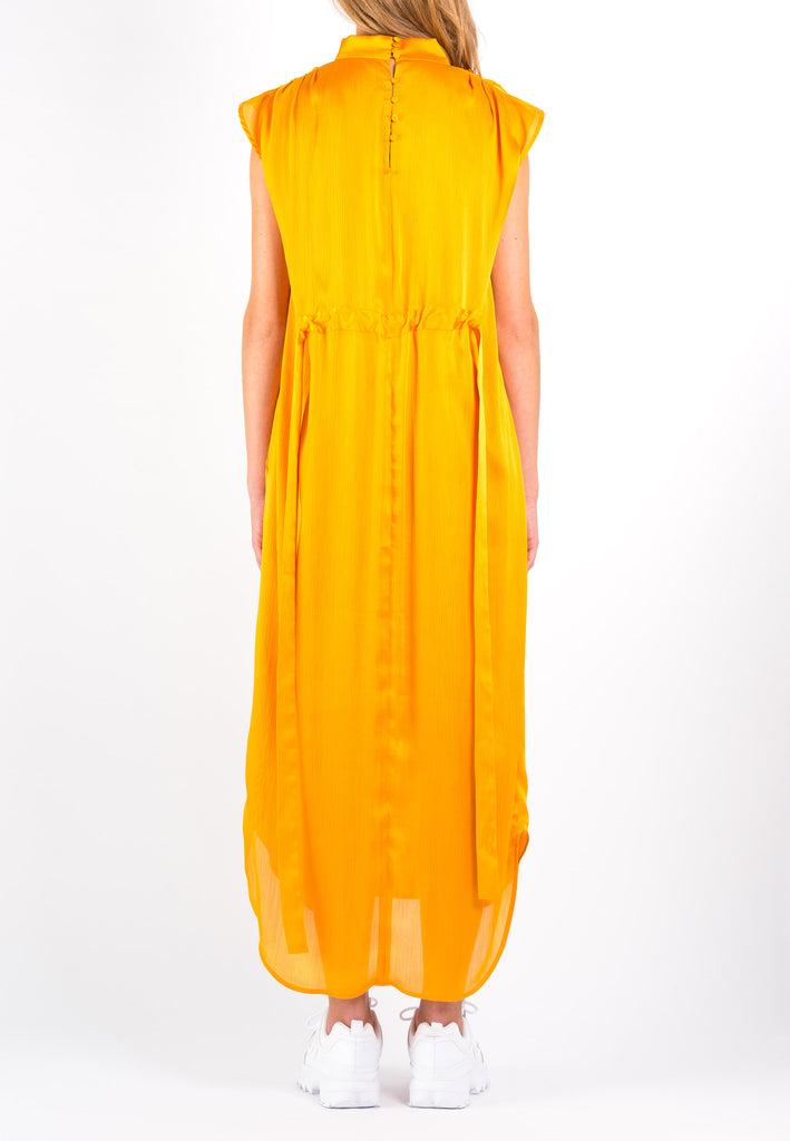 Conceal | Dress | Orange. Maxi dress in a wrinkle flowy satin light fabric. Wear it with the belt to create a waist or wear it without the belt and let the dress hang loose. Model wears a size 36.