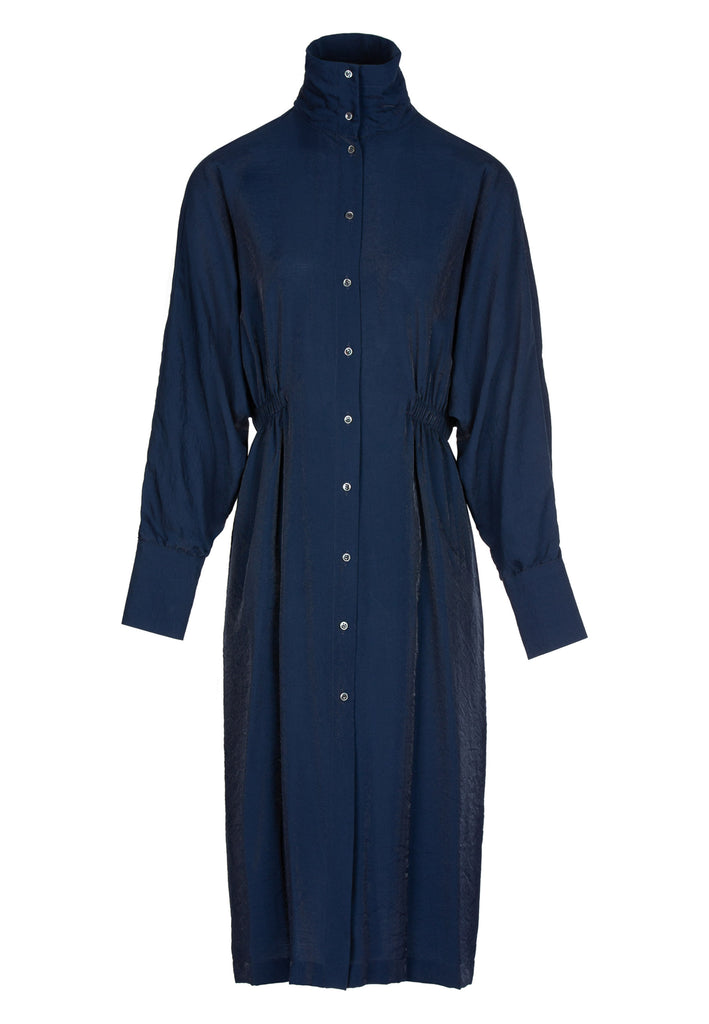Extent dress, bright navy color. Loose shirt dress and dropped shoulders that accentuate the loose fluid fit.With standup collar detailed with elastic details in the waist. Handy pockets.