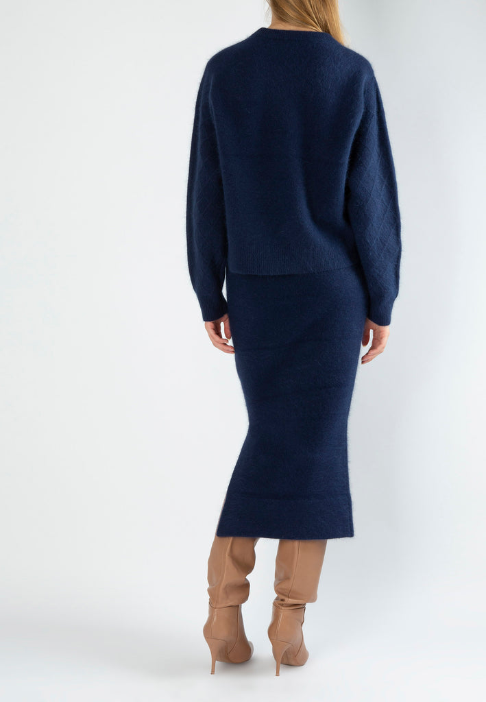 Navy tick skirt. 54% Merino wool, 18% Angora, 18% Nylon, 10% Elastane. Midi skirt finely knitted from soft fluffy care-gora in a figure-hugging silhouette and has a ribbed, elasticated waistband that sits at your narrowest point.