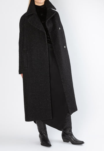 Black wanted coat. Designed by Erik Frenken. Powerful coat made from a herringbone wool blend. It a loose silhouette that's emphasized by dropped shoulders with oversized notched lapels. Using the self-tie inside strap to define your waist.