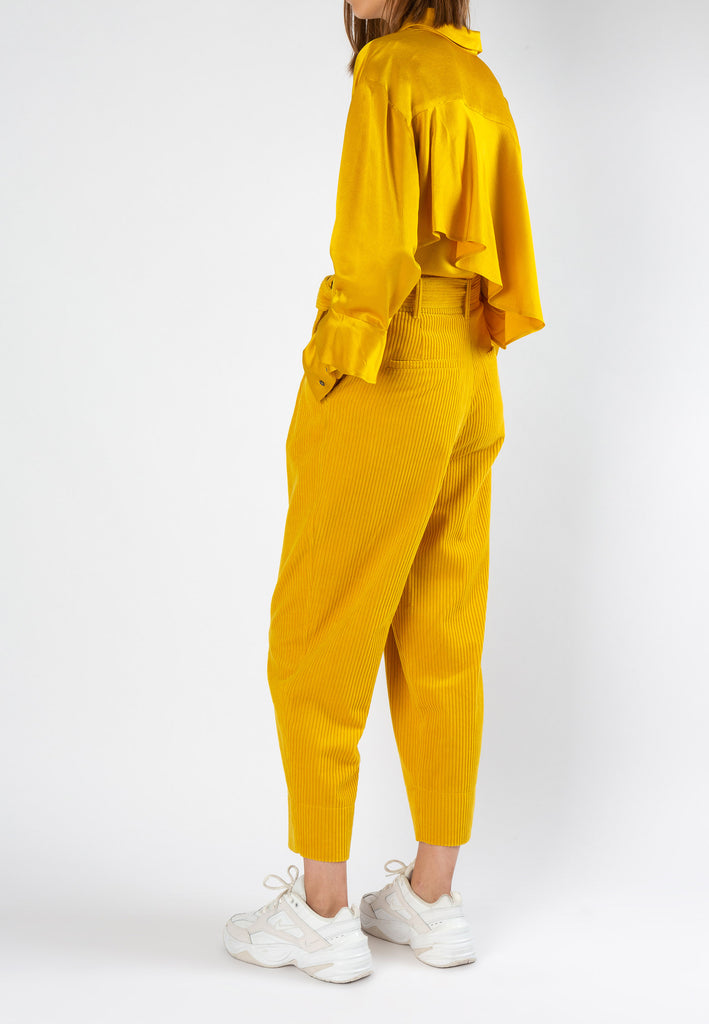Point | Shirt | Mustard. Cut from fluid structured satin in vibrant mustard yellow. Detailed with a ruffle at lower arms and exaggerated cuff. Wear it chic with our flapped skirt or style on jeans.