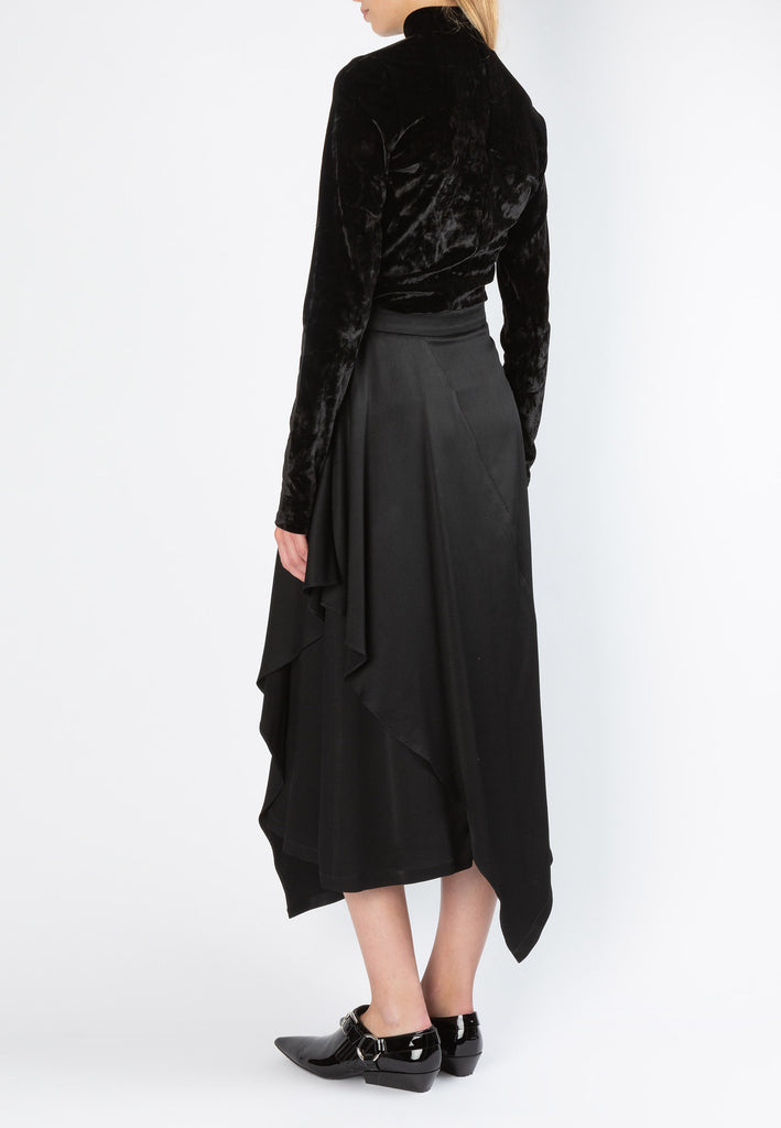 Flapped | Skirt | Black. Asymmetric ruffle midi skirt cut from fluid textured satin. This skirt sits on your natural waist and falls to an asymmetric hem that beautifully sways with each step. Model wears a size 36.