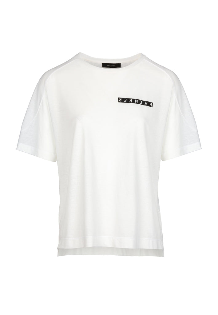 Off-white top. FRENKEN fashion. Relaxed fitted flimsy T-Shirt. Detailed with round seams at shoulder and printed mirrored logo.