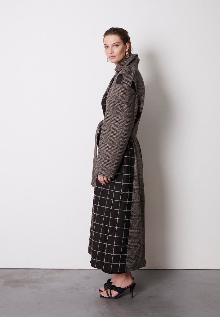 Oversized coat made from wool checks blending different designs, houndstooth and windowpane. This coat features an underlayer that is fully quilted and can be detached from the main sheld, adding warmth to the cooler days. This masterpiece frames Erik Frenken vision of cool oversized silhouettes mixing exquisite modelling details. Layer yours over everything, years to come.