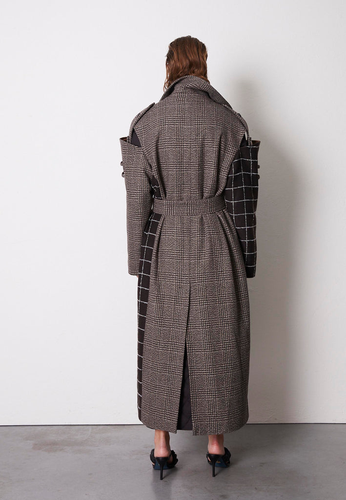 Oversized coat made from wool checks blending different designs, houndstooth and windowpane. This coat features an underlayer that is fully quilted and can be detached from the main sheld, adding warmth to the cooler days. This masterpiece frames Erik Frenken vision of cool oversized silhouettes mixing exquisite modelling details. Layer yours over everything, years to come.