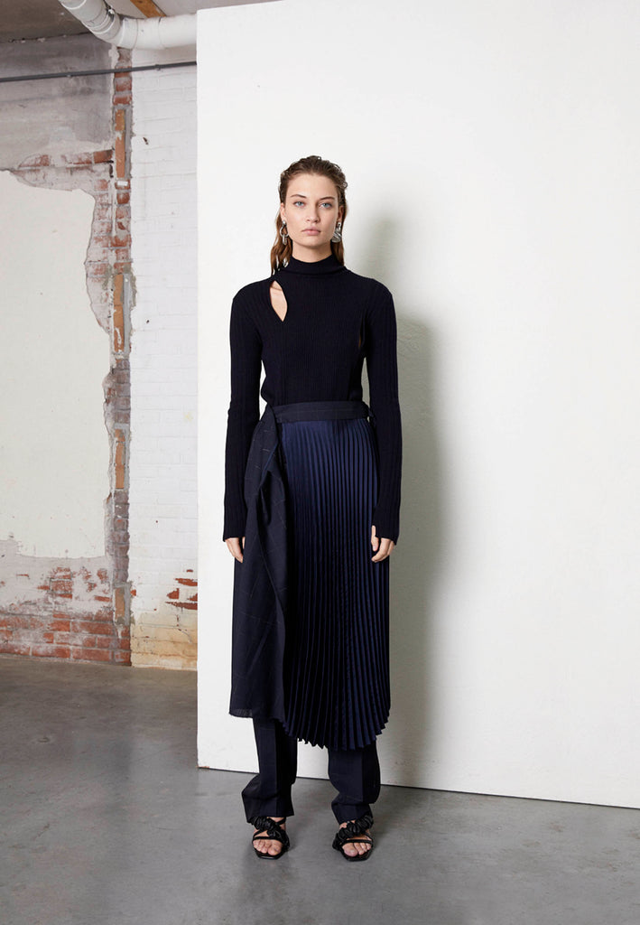 Crush skirt, navy color. Asymmetric deconstructed wrapped midi skirt. Detailed with raw edge at hem, a horn button and silver buckle at the waist. frenkenfashion.com