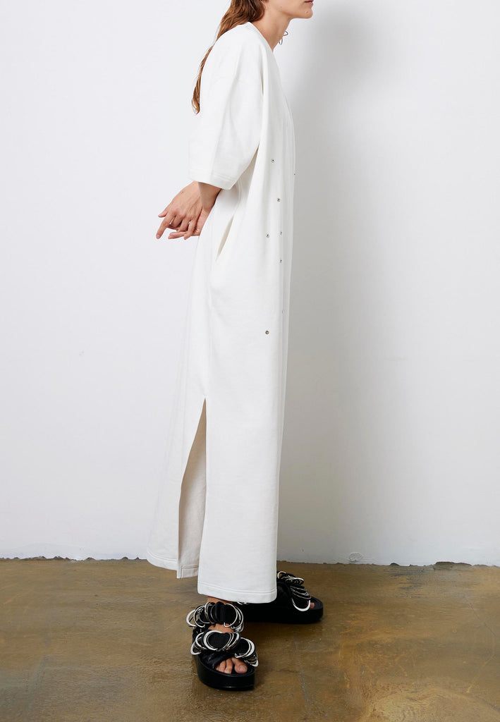 Peak | Dress | Off-white. Maxi dress fabricated in soft off-white interlock. The dropped sleeves emphasize the oversized look, with metallic eyelets and press buttons, inspired by the functionality, for an unexpected leisurewear statement piece. With side slits for extra comfort, to wear inside and out.