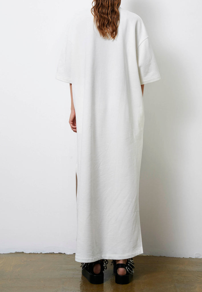 Peak | Dress | Off-white. Maxi dress fabricated in soft off-white interlock. The dropped sleeves emphasize the oversized look, with metallic eyelets and press buttons, inspired by the functionality, for an unexpected leisurewear statement piece. With side slits for extra comfort, to wear inside and out.