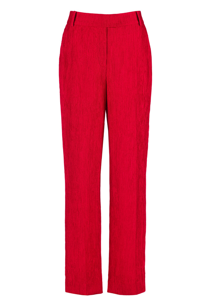 FRENKEN Troop fire red trouser, fluid and loose for a complete comfort. Accented with softly pressed creases for the perfect fitting. With belt loops, buttons, side and back pockets. Also available in off white.