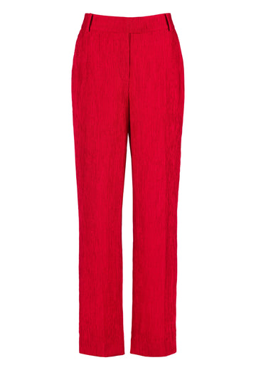 FRENKEN Troop fire red trouser, fluid and loose for a complete comfort. Accented with softly pressed creases for the perfect fitting. With belt loops, buttons, side and back pockets. Also available in off white.