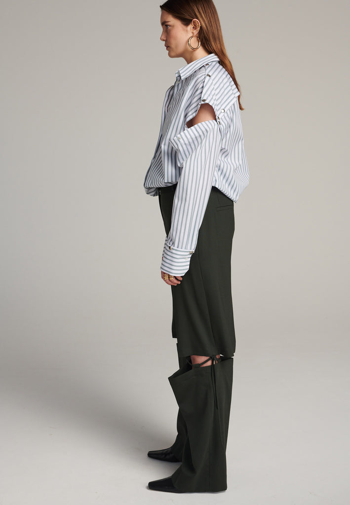 Oversized classic menswear inspred shirt. Cut from 100% crispy poplin cotton in white with dark green thin stripes. Detailed with metal press buttons at the armhole and cuffs to detatch them. The back yoke also features press-buttons! You can play with it by opening or closing the back cut-out.