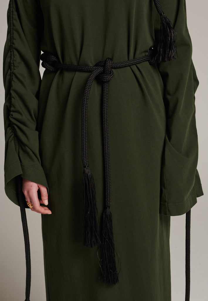 FRENKEN oversized jersey dress with long wide sleeves crafted in soft light dark green cotton, detailed with this season's cord theme. The chunky cords are displayed along the sleeves and can be pulled out to create shape and to shorten the sleeves, making the most of this statement style. The cord ends are hand frayed, a refined couture detail.