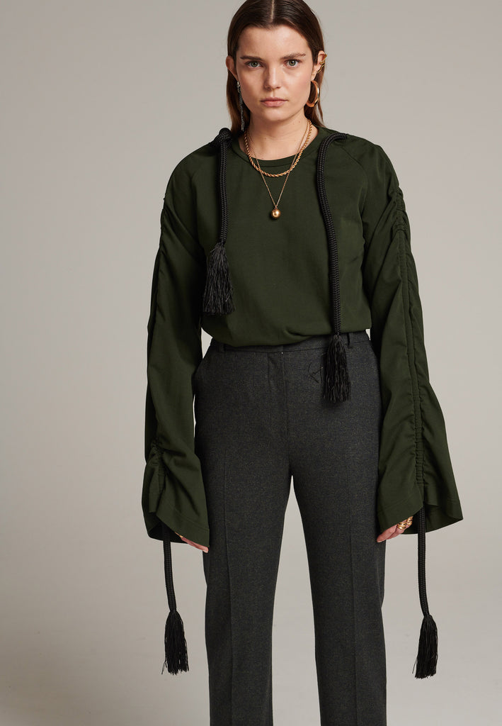 Oversized jersey with long wide sleeves crafted in soft dark green cotton, detailed with this season's cord theme. The chunky cords are displayed along the sleeves and can be pulled out to create shape and shorten the sleeves. The cord ends are hand frayed, a refined couture detail.