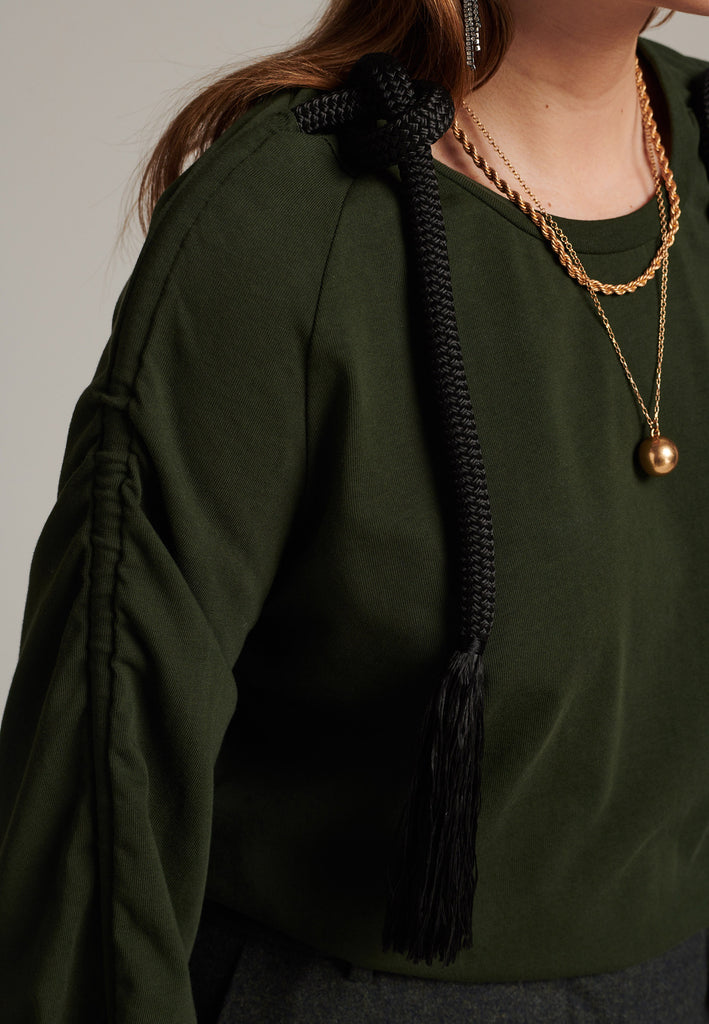 Oversized jersey with long wide sleeves crafted in soft dark green cotton, detailed with this season's cord theme. The chunky cords are displayed along the sleeves and can be pulled out to create shape and shorten the sleeves. The cord ends are hand frayed, a refined couture detail.