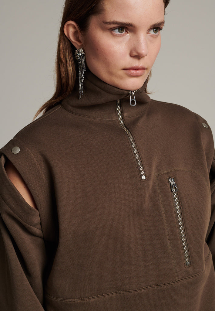 Boxy fitted sweater in dark camel with detachable sleeves to play with. Silver hardwear, zippers and metal press buttons. Detailed with stiched lines.