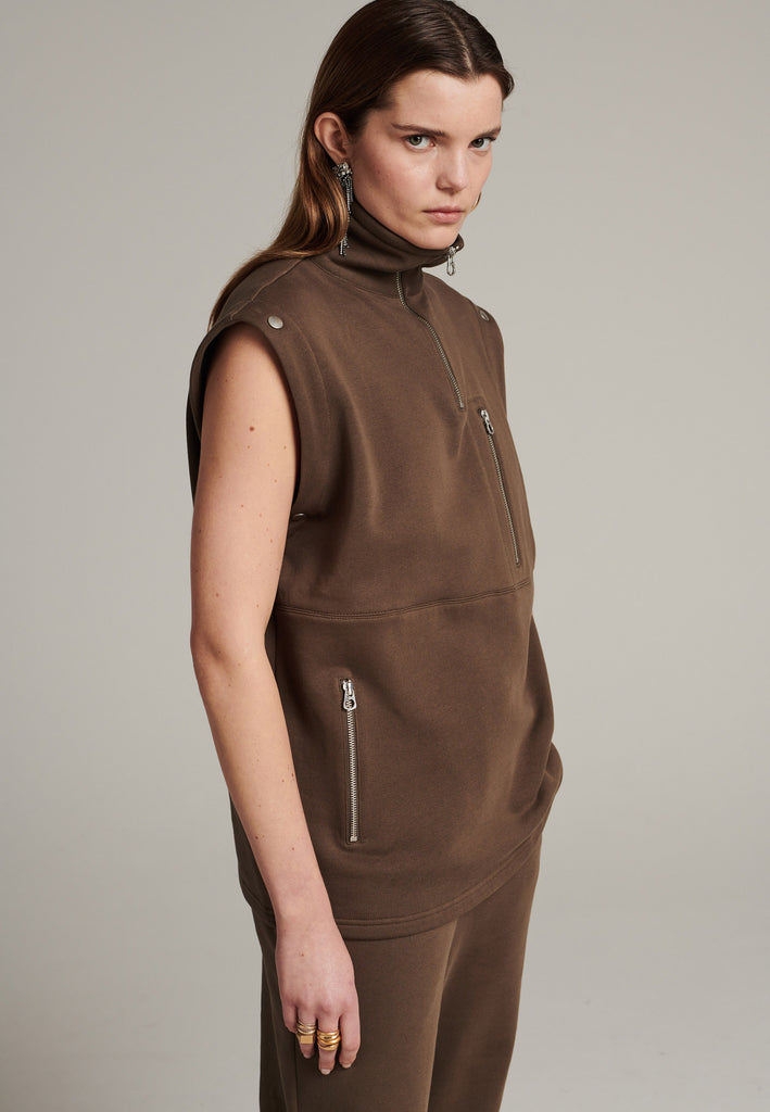 Boxy fitted sweater in dark camel with detachable sleeves to play with. Silver hardwear, zippers and metal press buttons. Detailed with stiched lines.