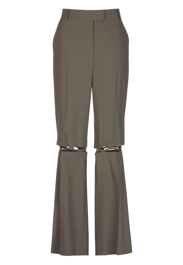 Boyish fitted straight leg trousers cut from fine light wool in dark camel. Detailed with a cut-out section right below the knee, held to the upper panels by a finely laced string. Can be worn elegantly open, loose or tied together.