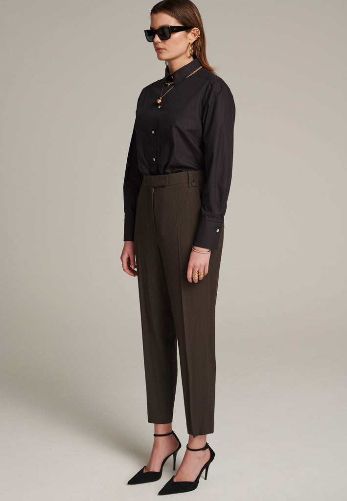 Cropped tailored choco pants cut in a wrinkled light suiting wool blend. Pressed front pleat to emphasize the sophisticated look. Refined with belt loops and horn buttons, welt pocket at the back.