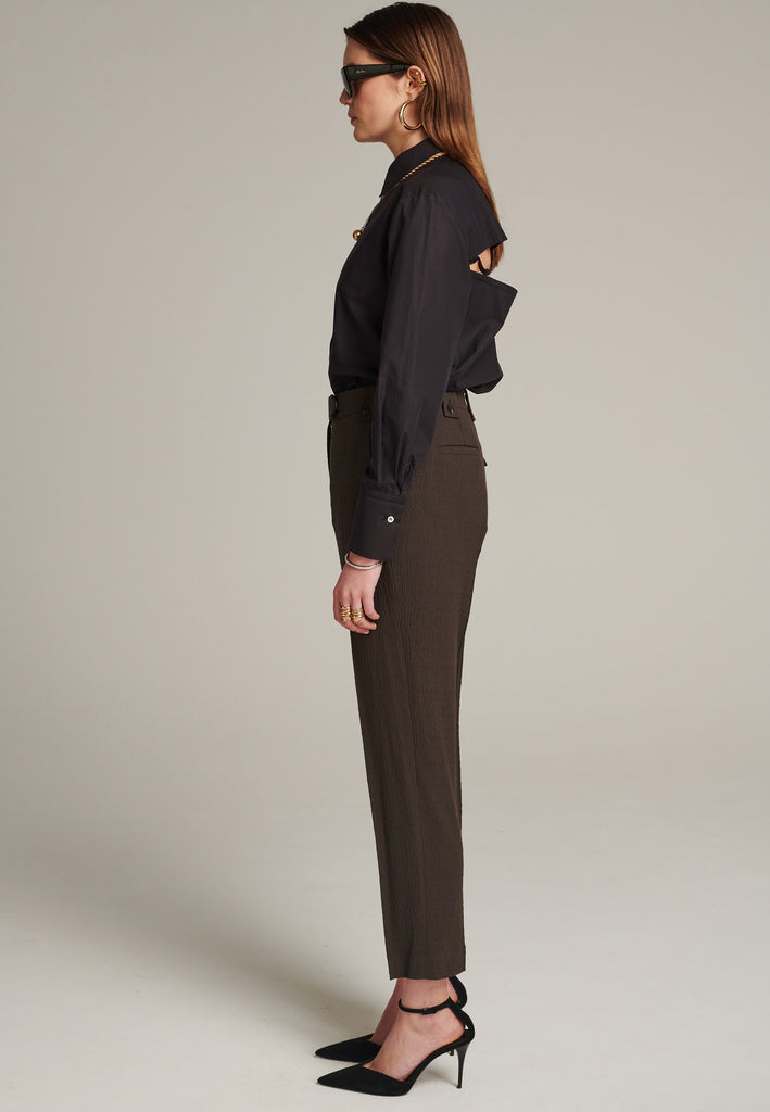 Cropped tailored choco pants cut in a wrinkled light suiting wool blend. Pressed front pleat to emphasize the sophisticated look. Refined with belt loops and horn buttons, welt pocket at the back.