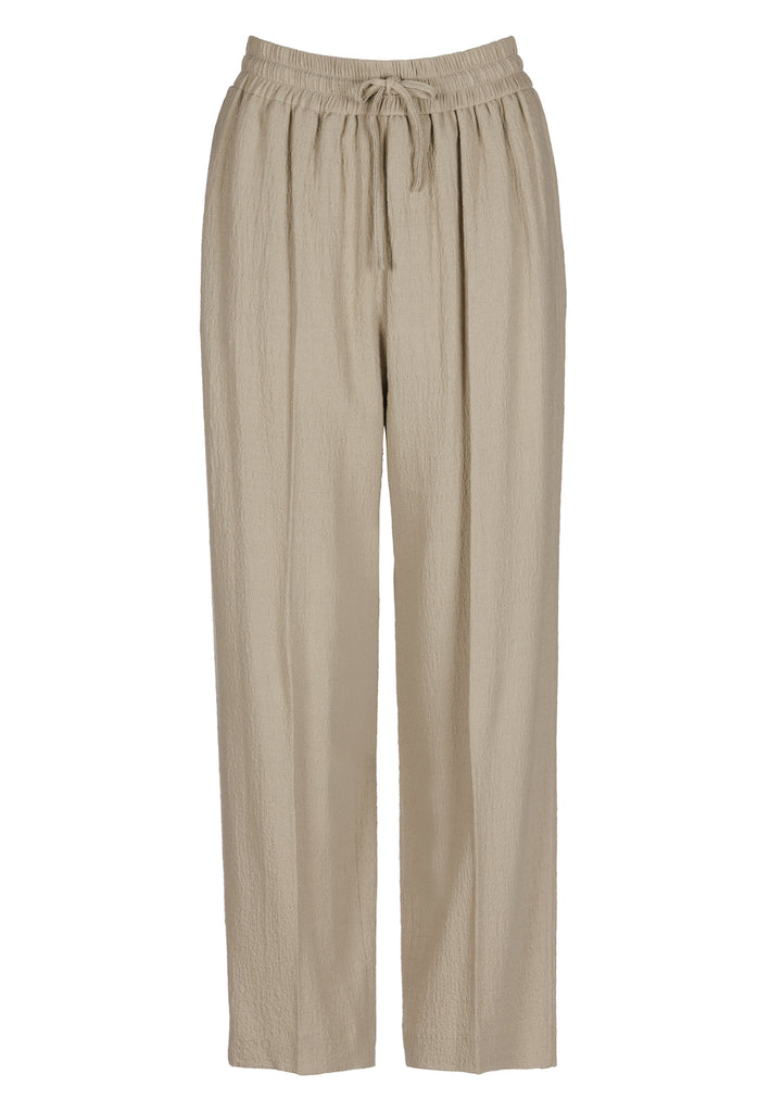 Cropped flowy pants in stone with a high-rise. Designed with a loose relaxed fit and drawstring flexible waistband. Pressed front pleat to create a more sophisticated look. Detailed with a welt pocket at the back.