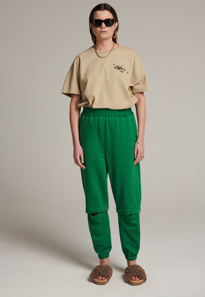 Relaxed fitted sweatpants in green. Cut from soft brushed terry. Detailed with metal press buttons turning the pipes into detachable. Relaxed high-rise silhouette with an elasticated waist and cuffs.