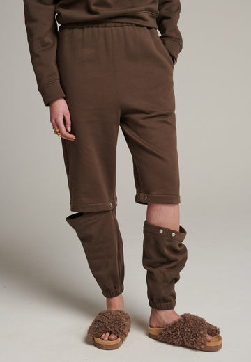 FRENKEN relaxed fitted sweatpants in dark camel. Cut from soft brushed terry. Detailed with metal press buttons turning the pipes into detachable. Relaxed high-rise silhouette with an elasticated waist and cuffs.