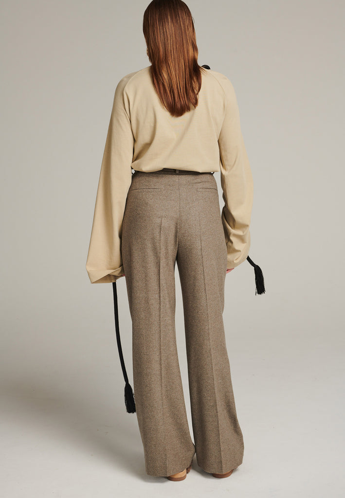 Pleated high-rise pants with wide-leg fitting made of a soft wool blend flannel in stone. It's designed to move beautifully as you walk. Back welt pockets. Menswear-inspired tailored waistband. One of the chicest ways to wear relaxed tailoring.