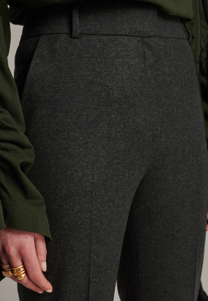 Mid-rise straight-leg pants that create a sleek silhouette. Made from a soft wool blend in back green with back welt pockets. Menswear-inspired tailored waistband. Pressed front pleat that elongates the leg for a sophisticated fitting.