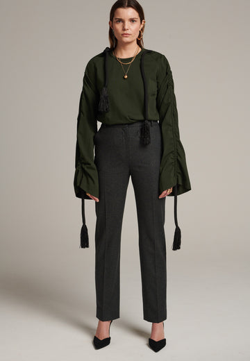 Mid-rise straight-leg pants that create a sleek silhouette. Made from a soft wool blend in back green with back welt pockets. Menswear-inspired tailored waistband. Pressed front pleat that elongates the leg for a sophisticated fitting.