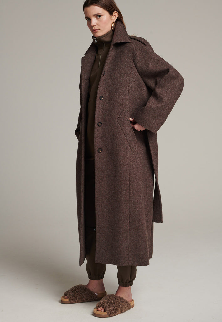 Oversized relaxed-fit coat in brown choco melange cut from a recycled soft wool blend, fully lined with satin. It comes with a coordinating belt backed with with contrasting grosgrain tape, to temper the loose fit and to cinch to the waistline.
