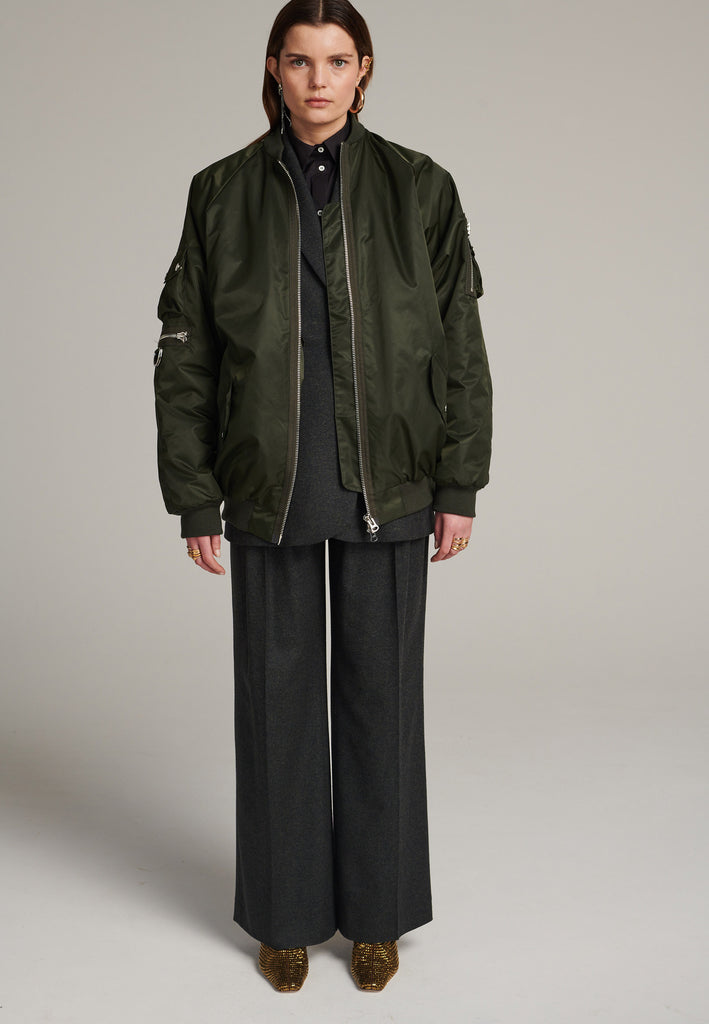 Tramp is already one of FRENKEN classics. This oversized padded bomber jacket in army green is made with heavy water-repellent cloth. Batwing sleeve cut with a wide elastic band under the arm to create a puckering effect at the seams. Detailed with chunky two-way zip. A true creative classic.