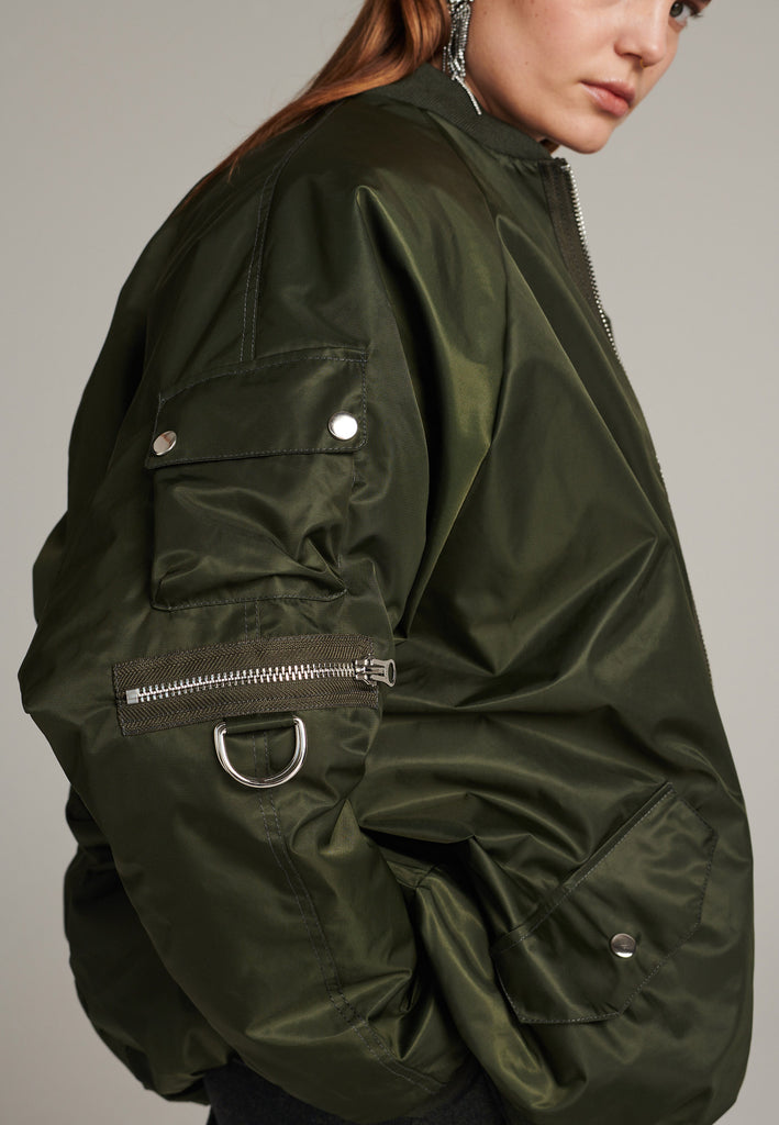 Tramp is already one of FRENKEN classics. This oversized padded bomber jacket in army green is made with heavy water-repellent cloth. Batwing sleeve cut with a wide elastic band under the arm to create a puckering effect at the seams. Detailed with chunky two-way zip. A true creative classic.