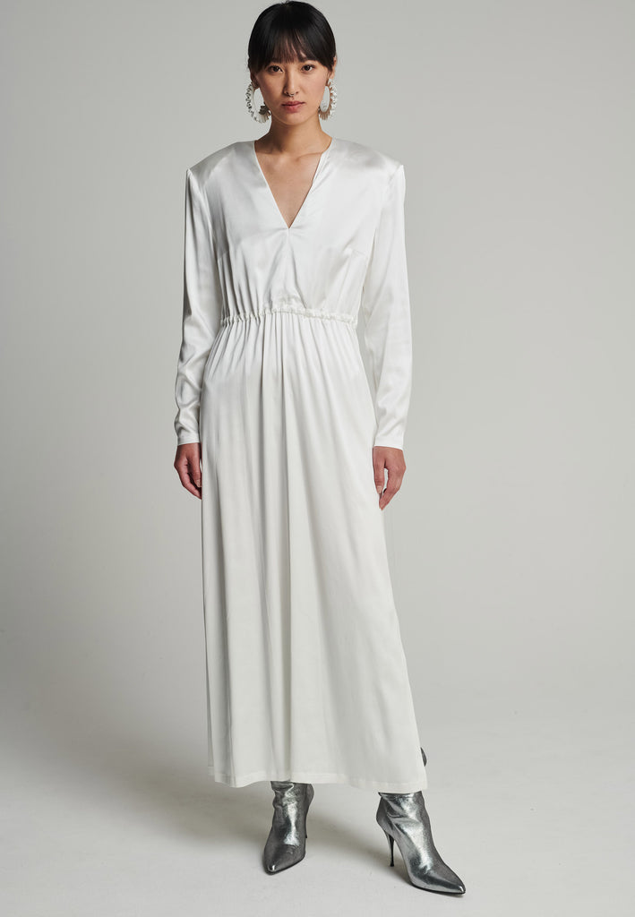 Shoulder-padded satin slim dress in off-white. Features a v-neck, back and leg openings, and an elastic waistband. True to size.
