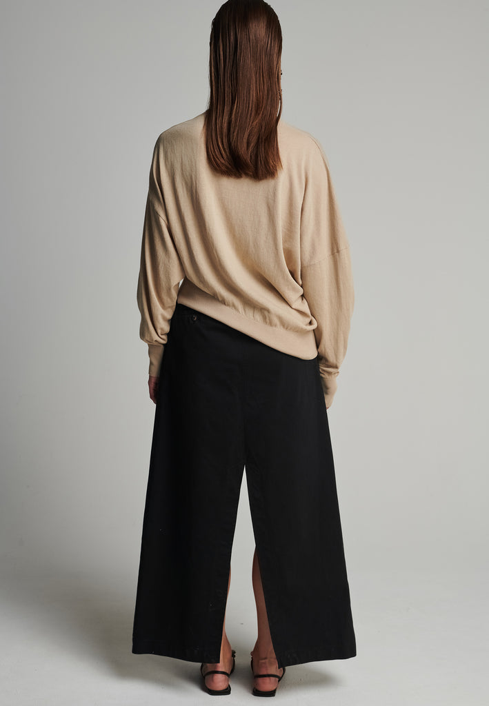 Cotton knitted loose jumper in camel. Features a v-neck, an asymmetric effect, and wide cuffs. True to size.