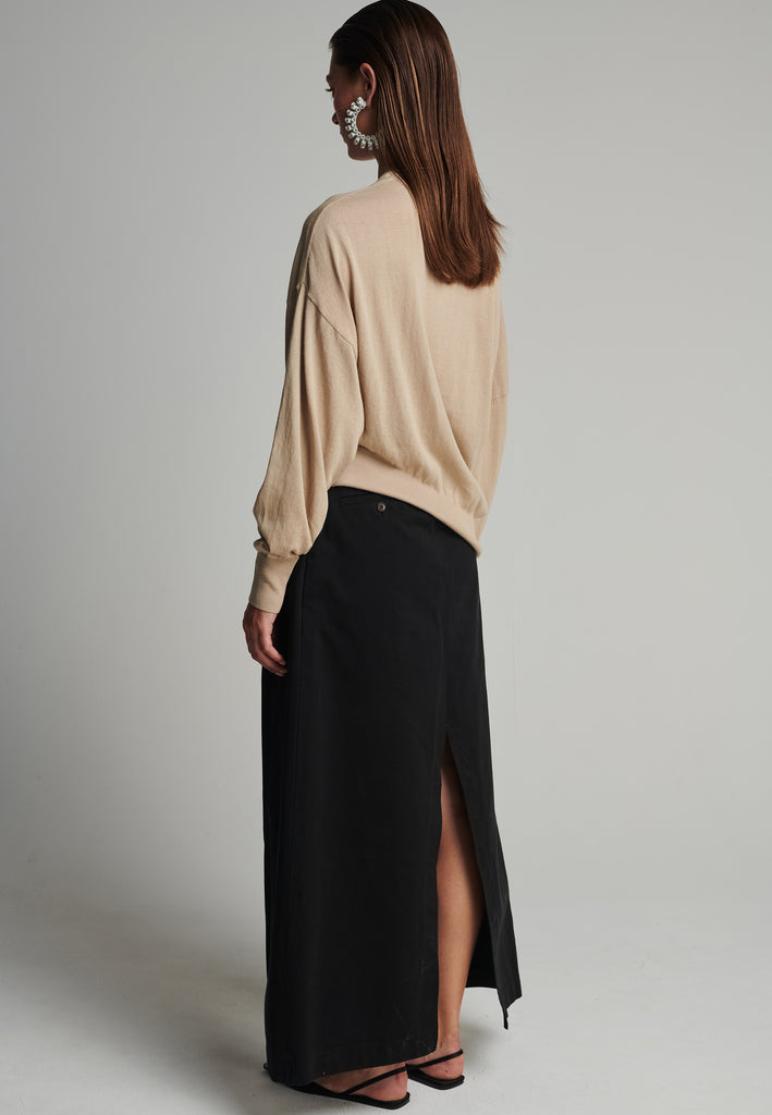 Cotton knitted loose jumper in camel. Features a v-neck, an asymmetric effect, and wide cuffs. True to size.