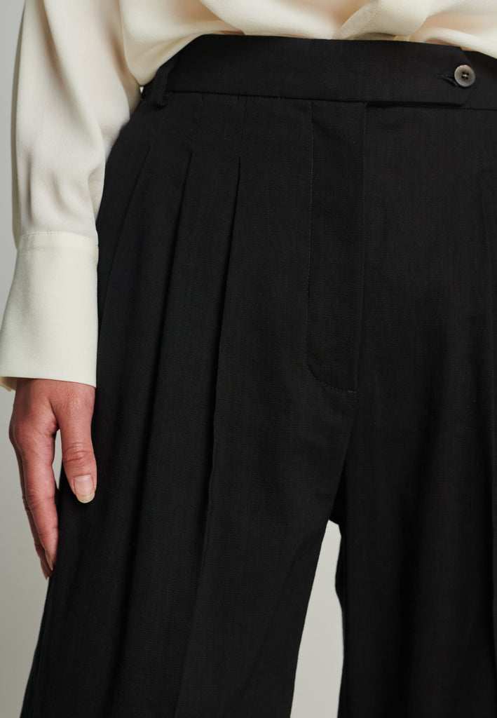 Wide-leg pants in black. Features pockets, belt loops, and pressed front pleats. True to size.