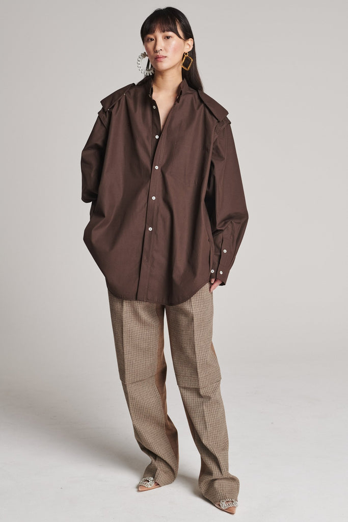 Wide-shouldered insideout shirt. Features an insideout collar stand and shoulder pads that can be detached. Detailed with a button fly-front and cuffs that can be closed in two different widths. Fits oversized.
