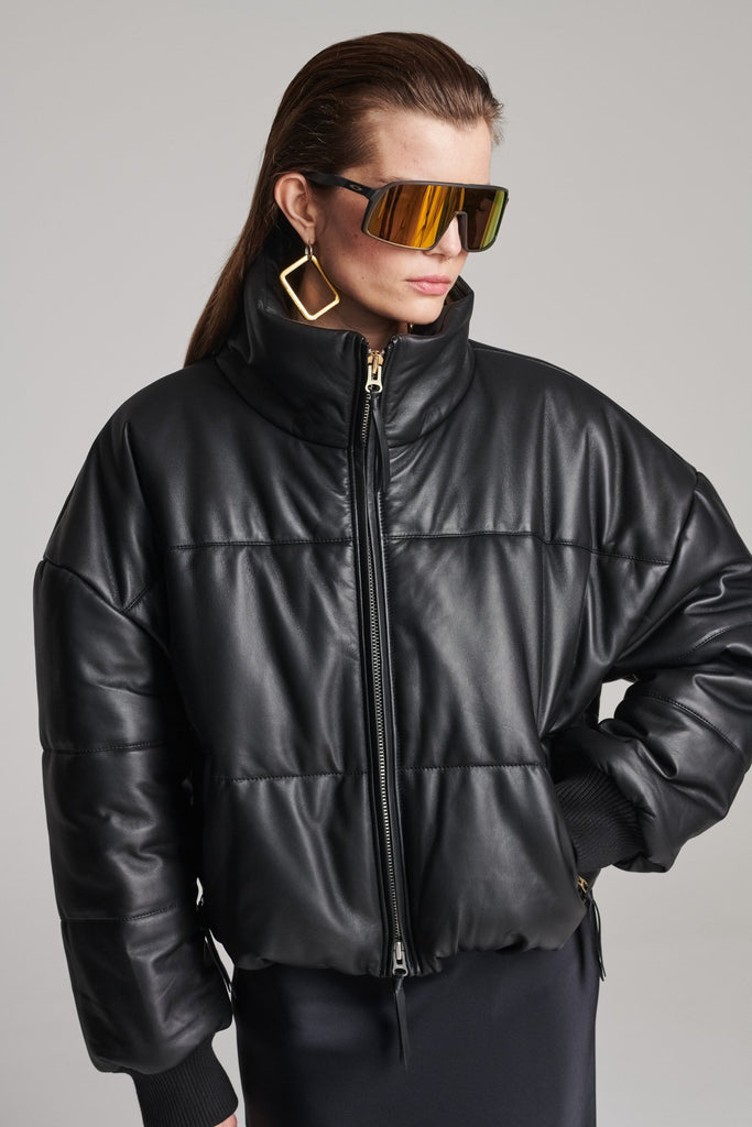 Wide-shouldered leather fully lined puffer coat. Features elasticated cuffs, zip fastening and pockets. Fits oversized.