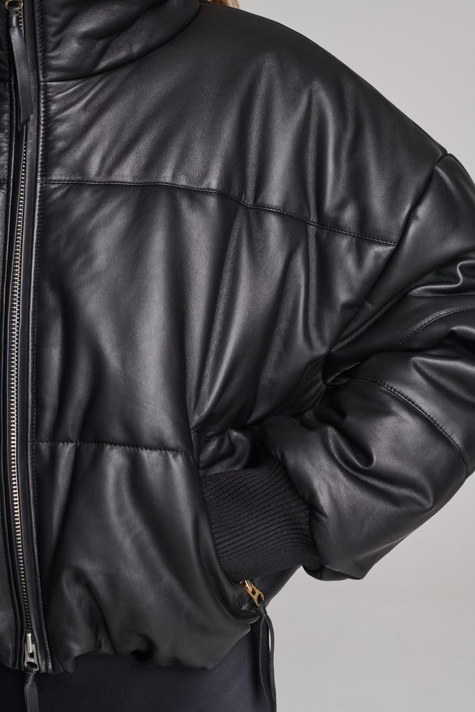 Wide-shouldered leather fully lined puffer coat. Features elasticated cuffs, zip fastening and pockets. Fits oversized.