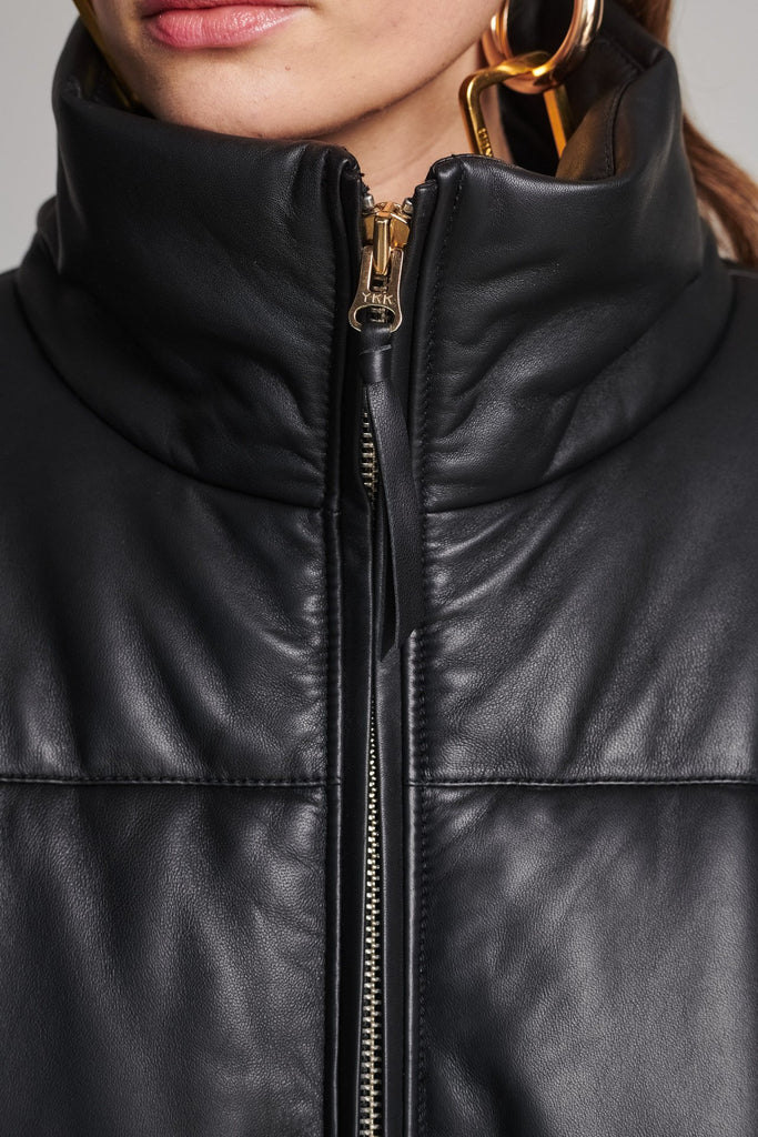 Wide-shouldered leather fully lined puffer coat. Features elasticated cuffs, zip fastening and pockets. Fits oversized.