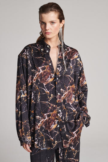 Wide-shouldered shirt with a shiny stretch brown digital marble print. Spiced-up with sprinkled dazzling Swarovski diamonds. Features a button fly-front. Fits oversize.