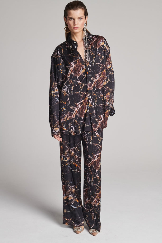 Wide-shouldered shirt with a shiny stretch brown digital marble print. Spiced-up with sprinkled dazzling Swarovski diamonds. Features a button fly-front. Fits oversize.
