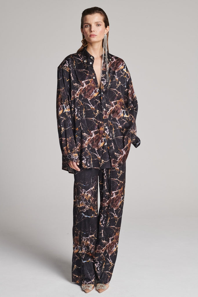 Wide-shouldered shirt with a shiny stretch brown digital marble print. Spiced-up with sprinkled dazzling Swarovski diamonds. Features a button fly-front. Fits oversize.